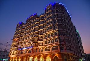 a tall building with lights on the side of it at Muscat Plaza Hotel in Muscat
