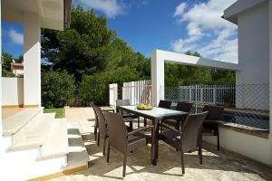 a patio with a table and chairs on a patio at Villa Sirenes in Playa de Muro