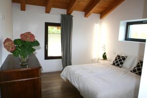 1 dormitorio con 1 cama y un jarrón de flores en Civico1A1 en Veternigo