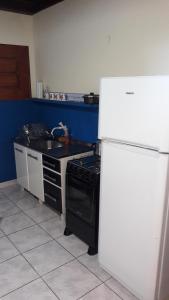 una cucina con piano cottura e frigorifero bianco di Flia Ocampo a Puerto Iguazú