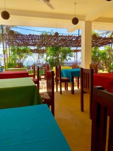 a restaurant with blue and green tables and chairs at Coppenrath Hostel in Tangalle