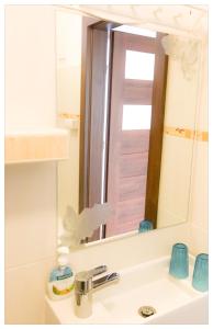 a bathroom sink with a large mirror above it at Apartament Katarzynka Stare Miasto in Toruń +1 photo