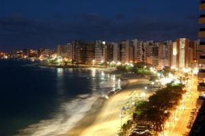 vista para uma praia à noite com edifícios em Pousada do Castelo em Fortaleza
