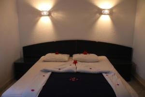 ファイユームにあるNew Panorama Resortの白いシーツと赤い花が飾られたベッド