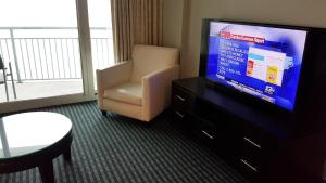um quarto de hotel com uma televisão e uma cadeira em 1906 OO em Myrtle Beach