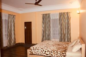 a bedroom with a bed and a ceiling fan at Denzong House in Kalimpong