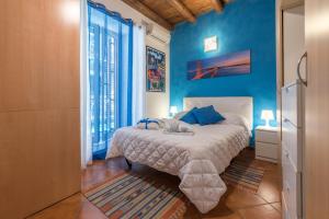 a bedroom with a bed with blue walls at Kasavucciria Apartments in Palermo