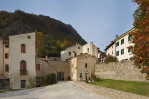 a group of buildings next to a stone wall at casa riva piazzola in Vittorio Veneto