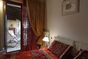 1 dormitorio con cama, ventana y silla en casa riva piazzola, en Vittorio Veneto