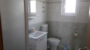 a bathroom with a toilet and a sink and a window at Apartmani Luna in Novalja +42 photos