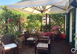 a patio with two chairs and an umbrella at Hepburn Holiday Home in Salerno