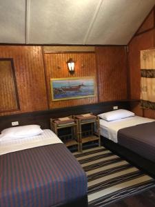 una habitación con 2 camas y una mesa en un barco en Thai Terrace Bungalow, en Thong Nai Pan Yai