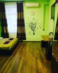 a bedroom with a tree and a clock on the wall at Art Galery Hostel in Lviv