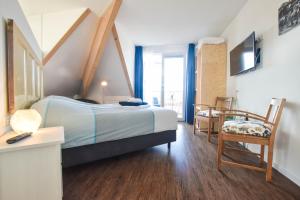 ザウテランデにあるTable d'Hôte Teune & Jannaのベッドルーム1室(ベッド1台、テーブル、椅子付)