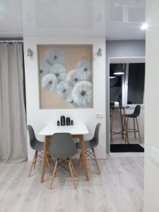 a dining room with a white table and chairs at Студия на Соборной 58 in Khmelʼnytsʼkyy