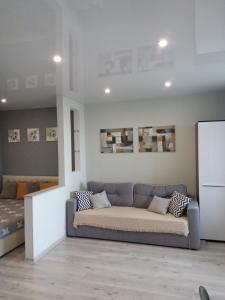 a living room with a couch and a bed at Студия на Соборной 58 in Khmelʼnytsʼkyy