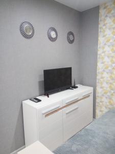 a bedroom with a white dresser with a tv on it at Студия на Соборной 58 in Khmelnytskyi