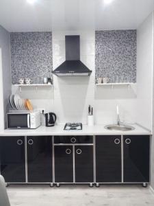a kitchen with a sink and a microwave at Студия на Соборной 58 in Khmelʼnytsʼkyy