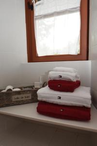 un mucchio di asciugamani seduti su una mensola in bagno di La Corrérie a Les Grandes-Armoises