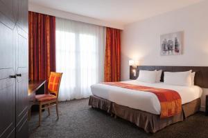 Habitación de hotel con cama grande y escritorio. en La Berteliere, The Originals Relais (Qualys-Hotel) en Saint-Martin-du-Vivier