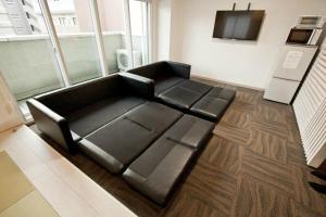 um sofá preto sentado num quarto em Place 11 Building / Vacation STAY 2139 em Sapporo