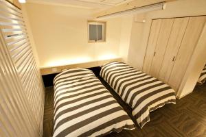 duas camas listradas num quarto com um armário em Place 11 Building / Vacation STAY 2139 em Sapporo