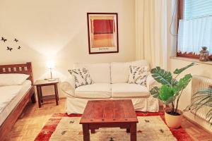 a living room with a couch and a coffee table at Wohnen im Kolonialstil inklusive Tiefgarage, kontaktloser Check-in in Klagenfurt