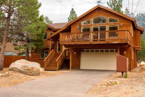 uma casa de madeira com um grande deque e uma garagem em 5-Star Luxury Tahoe Cabin! Great Location! Pool Table!Darts! Poker! Ping Pong! Games! em South Lake Tahoe