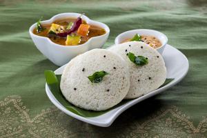 a plate of food with bowls of soup on a table at Babusona Homestay in Jaldapara in Mādāri Hāt