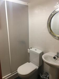 a white bathroom with a toilet and a sink at Casa-Apartamento Madera y Sol in Lubia +13 photos