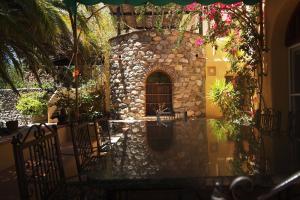 un edificio de piedra con mesa, sillas y flores en Paraíso Rural, en Órgiva