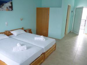 1 dormitorio con 1 cama con 2 toallas en Alexandros Guest House, en Skiathos