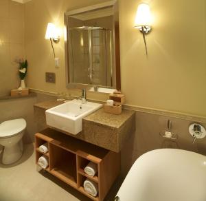 
a bathroom with a sink, toilet and mirror at Soho Hotel & Casino at Sun City in Sun City
