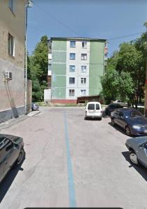 un aparcamiento vacío con coches estacionados frente a un edificio en Apartment near city center on Peremohy Avenue 46, en Cherníhiv