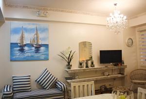 a living room with a couch and a painting of sailboats at Amaia Steps Capitol Central in Bacolod