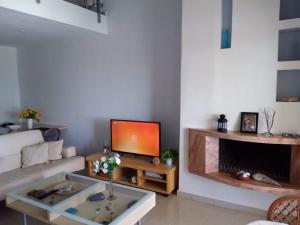 a living room with a couch and a tv at Two-storey Beachfront Maisonette in Toroni
