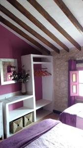 1 dormitorio con cama blanca y paredes moradas en Casa Rural Ubeda Pinoso-Alicante, en Úbeda