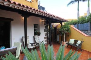 a porch of a house with chairs and a table at La Cuadra in Buenavista del Norte