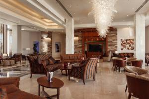 a lobby with chairs and tables and a chandelier at Xperience Kiroseiz Parkland in Sharm El Sheikh