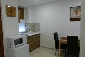 A kitchen or kitchenette at Wolf House Apartman