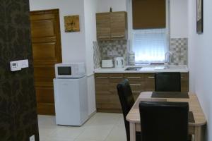 A kitchen or kitchenette at Wolf House Apartman