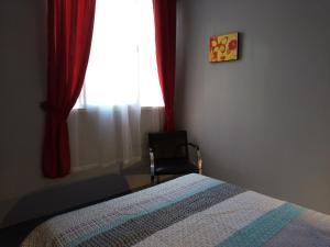 a bedroom with a bed and a chair and a window at Los Nietos Alojamientos in Mendoza