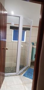 a glass shower door in a bathroom with a window at Flamingo Cottage no 12 in Meersig