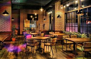 "METROPOL" APARTMENT HOTEL في باكو: مطعم بطاولات وكراسي وجدار من الطوب