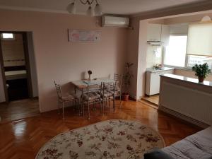 a kitchen and a dining room with a table and chairs at Transilvanya Apartament in Hunedoara