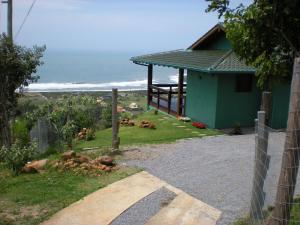 una casa al lado de una carretera con el océano en Panorâmica Praia da Silveira, en Garopaba