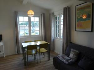 een woonkamer met een tafel en stoelen en een bank bij Appartement les Elfes in Capbreton