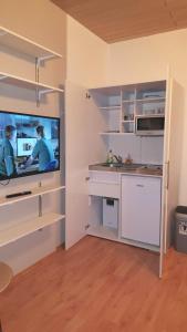 Cette chambre dispose d'une cuisine avec une télévision murale. dans l'établissement Monteur Apartment Valeria, à Hagen