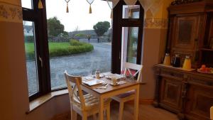 einen Tisch und Stühle in einem Zimmer mit Fenster in der Unterkunft Leroy´s Lodge in Headford