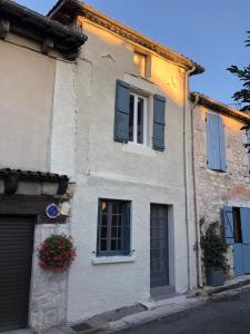 a building with blue shutters and a window at la Salaberie in Villeréal